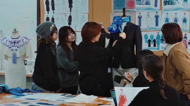 東華大學服裝與藝術設計學院師生團隊在討論結構細節。學校供圖