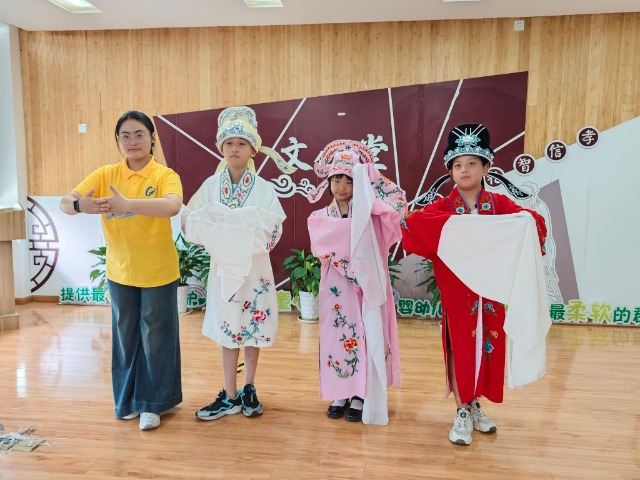 寧波職業(yè)技術(shù)大學(xué)“拾夢非遺”服務(wù)隊教小朋友們學(xué)唱傳統(tǒng)戲曲 學(xué)校供圖.jpg