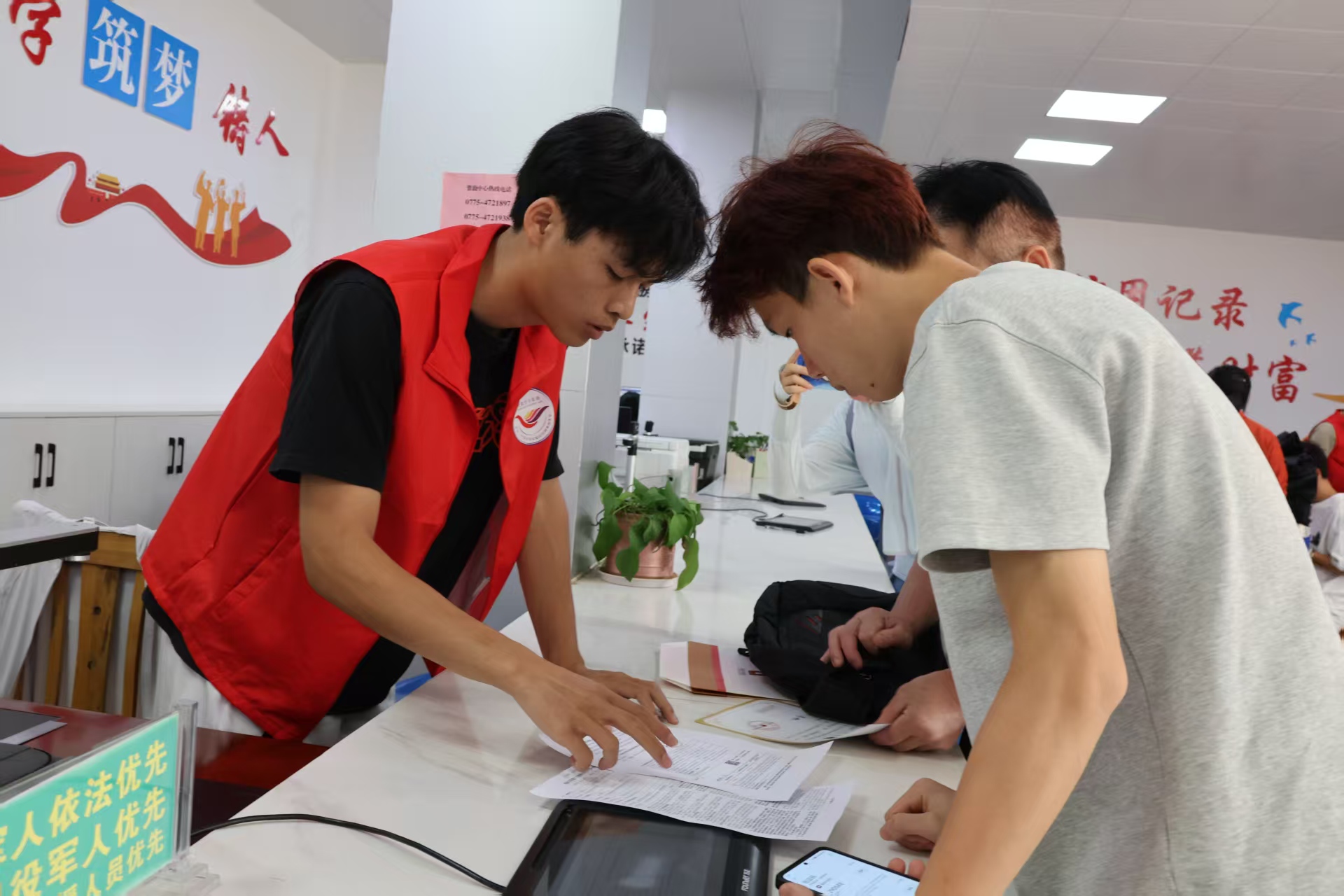 覃塘區(qū)：志愿者指引前來辦理貸款業(yè)務的學生.jpg