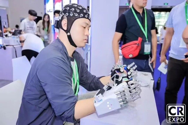 團隊成員在2025中國國際福祉博覽會暨中國國際康復展覽會展示手部康復機器人 學校供圖.jpg