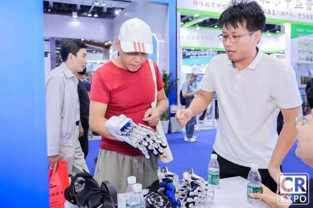 于金須在博覽會上向來賓介紹手部康復機器人 學校供圖.jpg